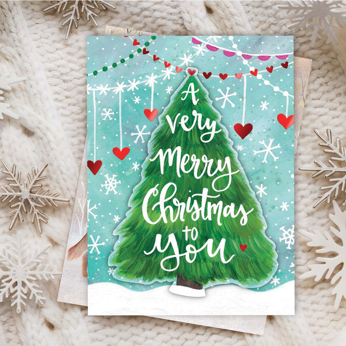 Christmas card with a green tree and 'Merry Christmas to You' text on a textured surface.