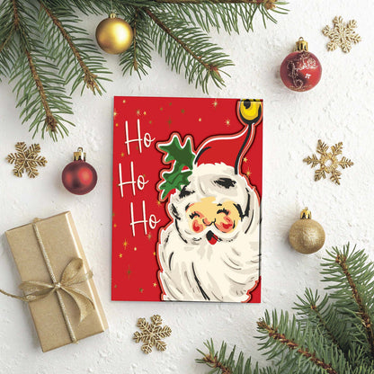 Red Christmas card with Santa Claus and 'Ho Ho Ho' text, surrounded by festive decorations on a white background.