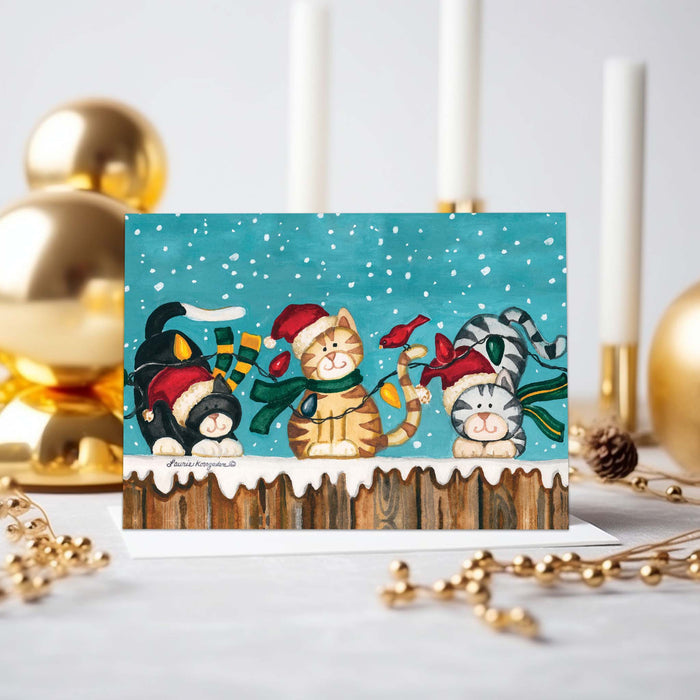 Christmas-themed card with cartoon cats in festive hats on a decorative background.